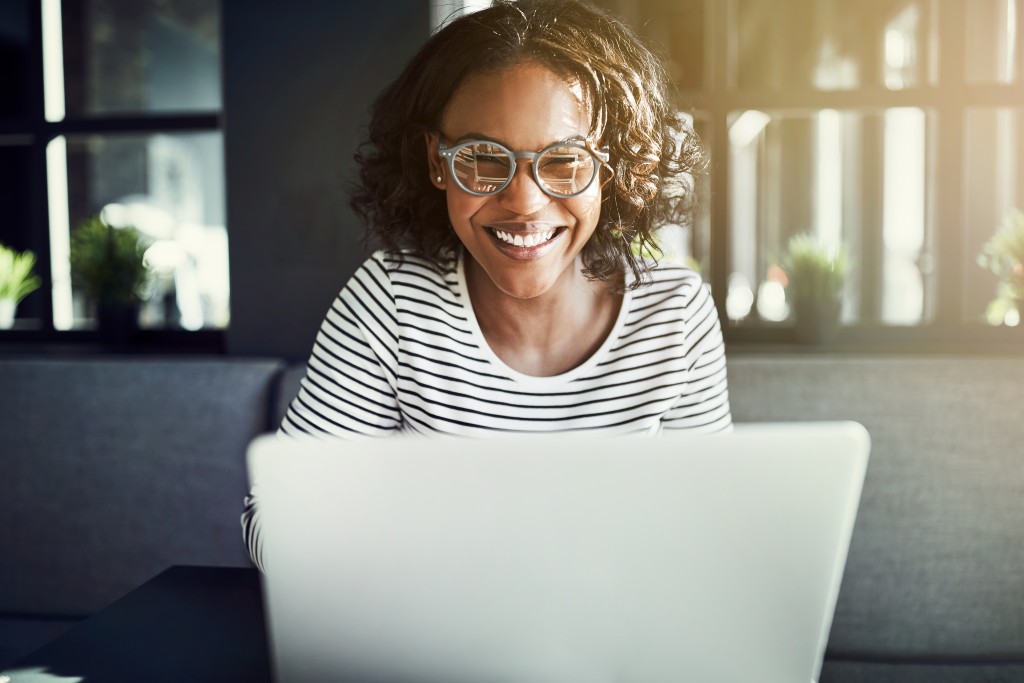 Female smiling while working in her laptop