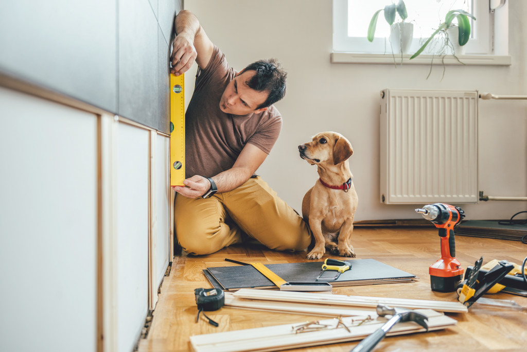 man doing home renovation with his pet dog