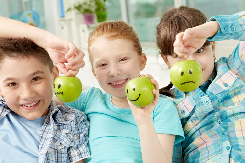 children holding green apples