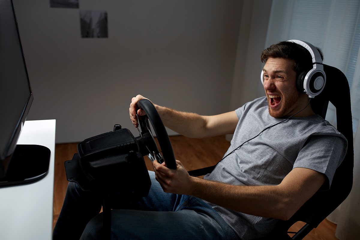 man driving car virtual game in his room